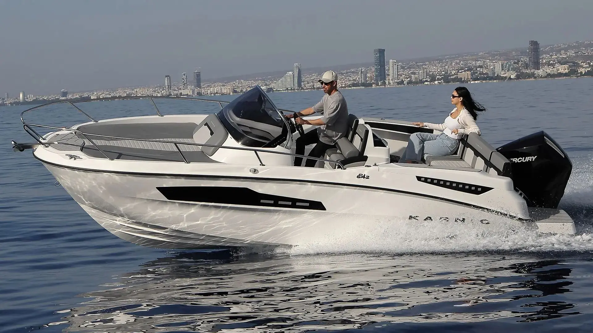 Karnic SL642 — Bateau à moteur blanc vu de profil, naviguant avec deux personnes à bord.