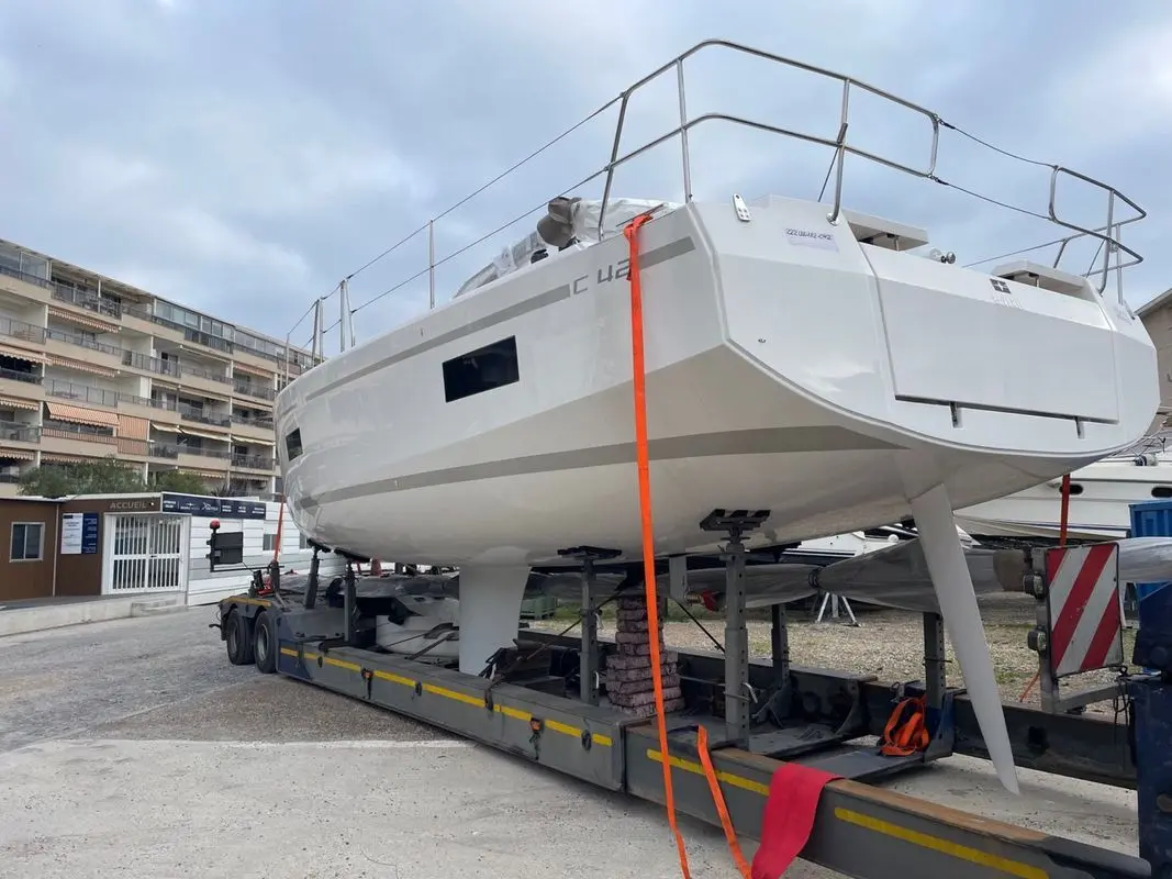 Bavaria c 42 — Voilier blanc vu de trois-quarts arrière, posé sur une remorque dans une marina.