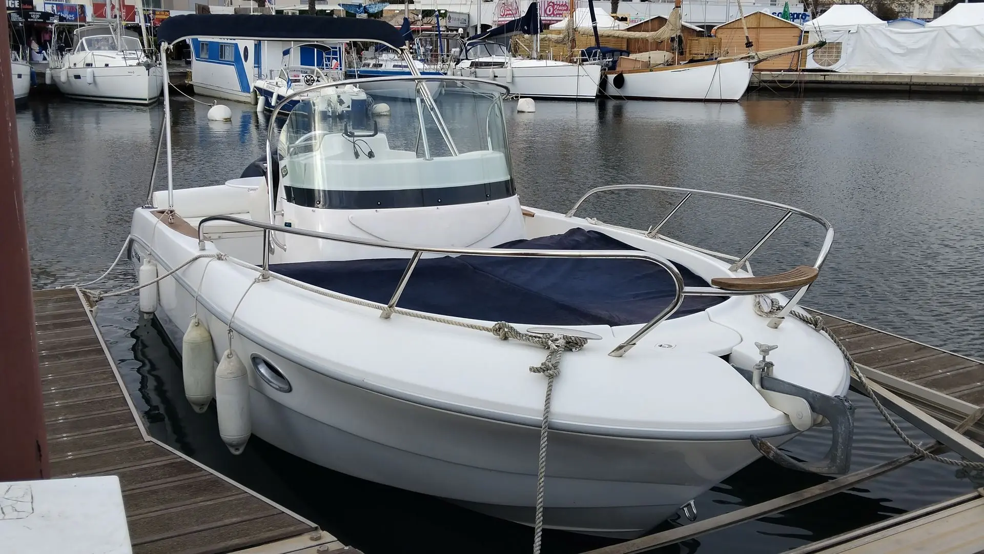 Sessa Marine Key Largo 22 — Bateau à moteur blanc amarré dans un port, vu de trois quarts avant.