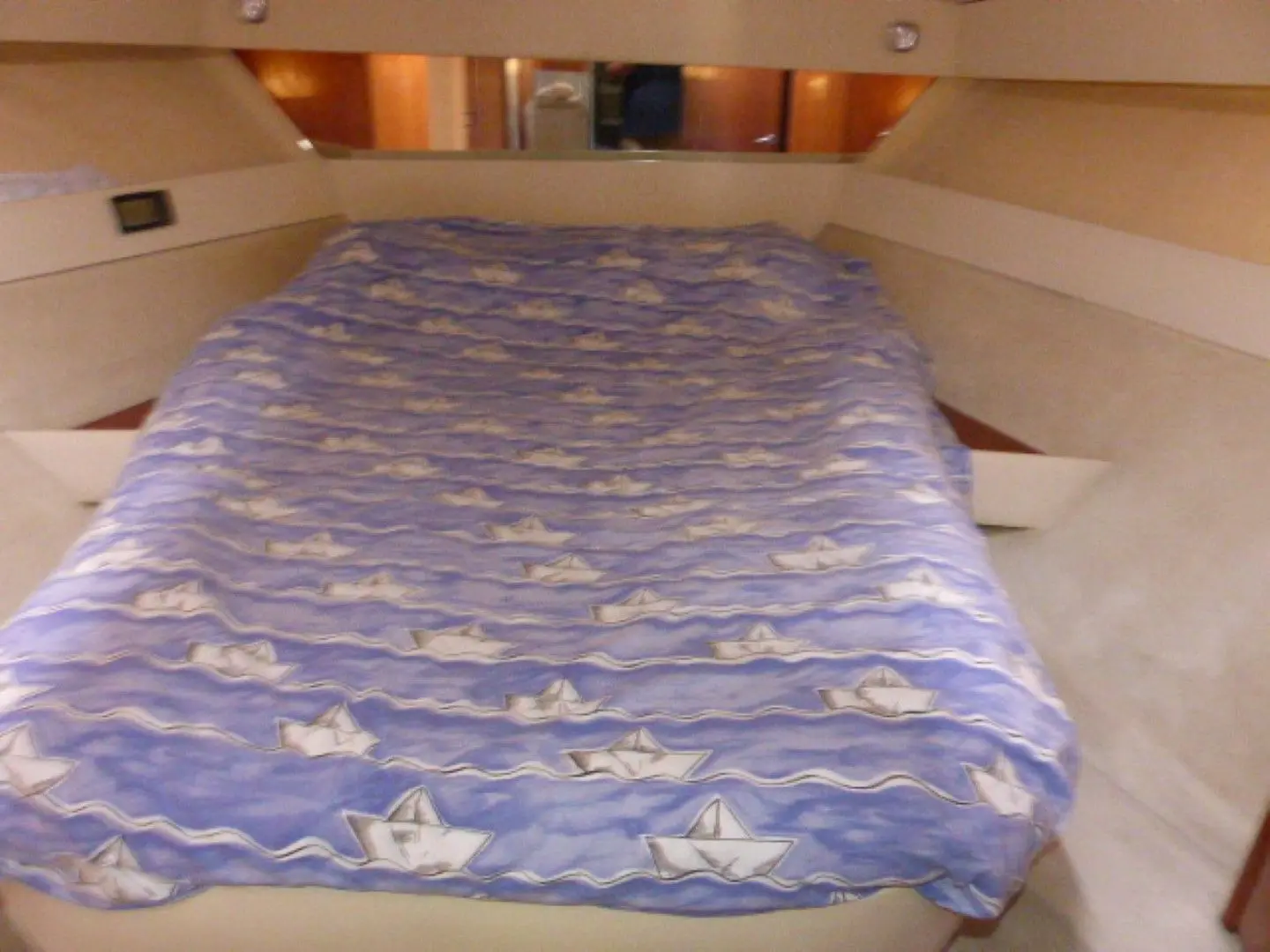 Azimut 37 — Couchette double avec literie bleue dans une cabine intérieure.