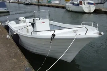 Fibramar Pescador 600 Open — Bateau à moteur blanc amarré dans un port, vu de trois quarts avant.