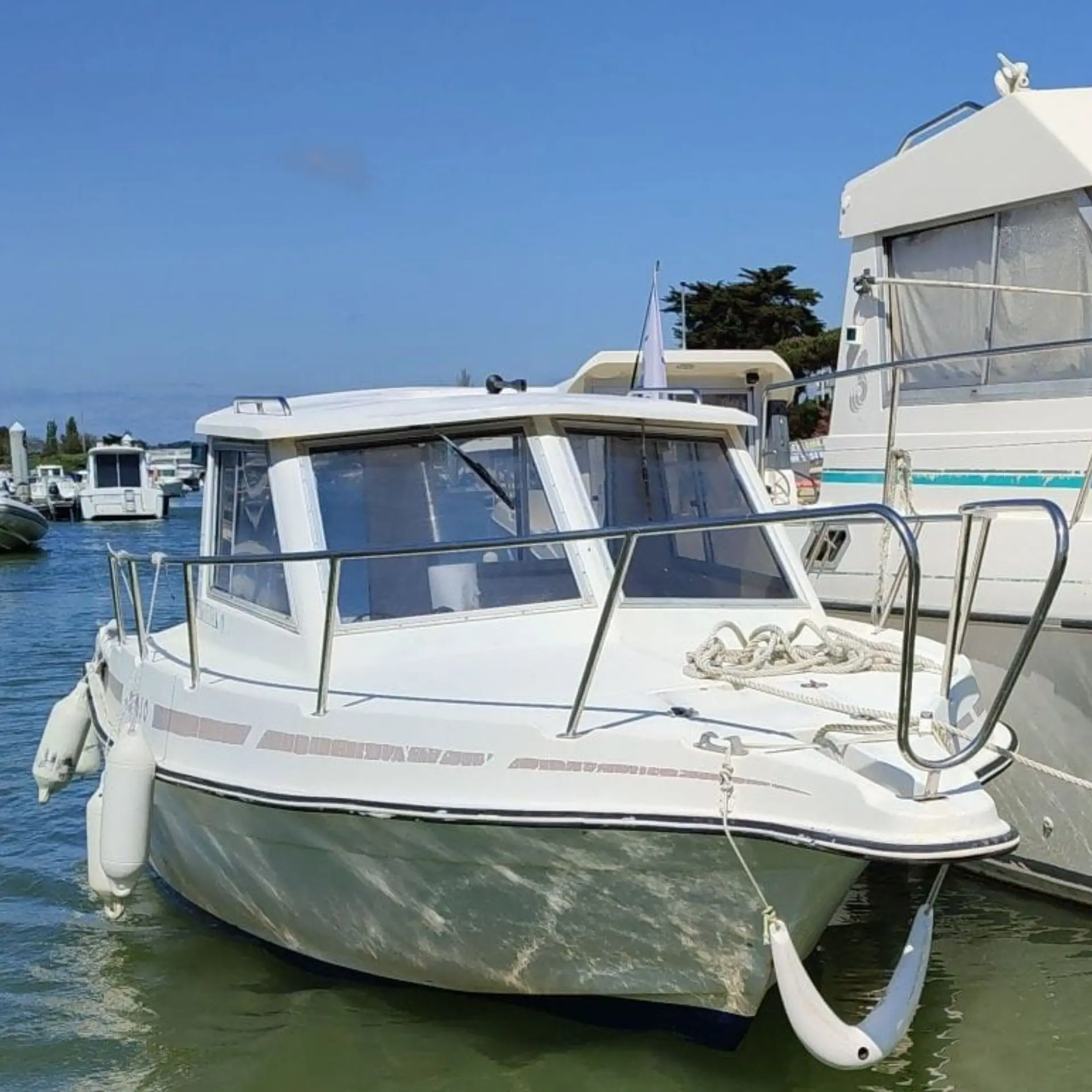 Guymarine GM 650 — Bateau à moteur blanc amarré dans un port, vu de trois quarts avant.