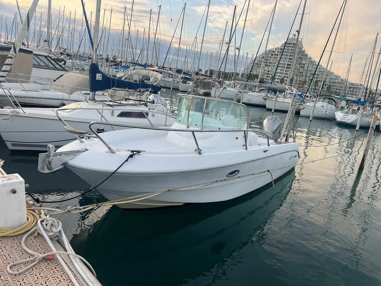 Sessa Marine Key Largo 25 — Vedette blanche amarrée dans un port, vue de trois quarts avant.