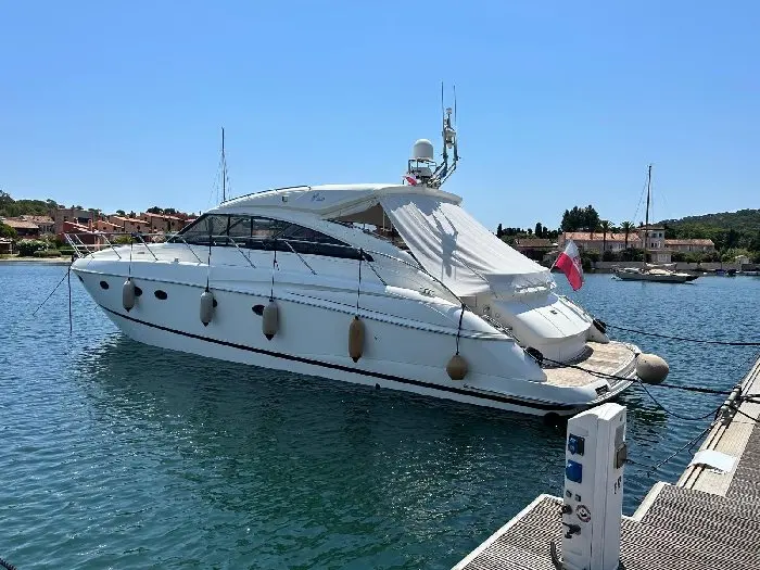 Princess V53 — Bateau à moteur blanc amarré dans une marina, vu de trois quarts arrière.