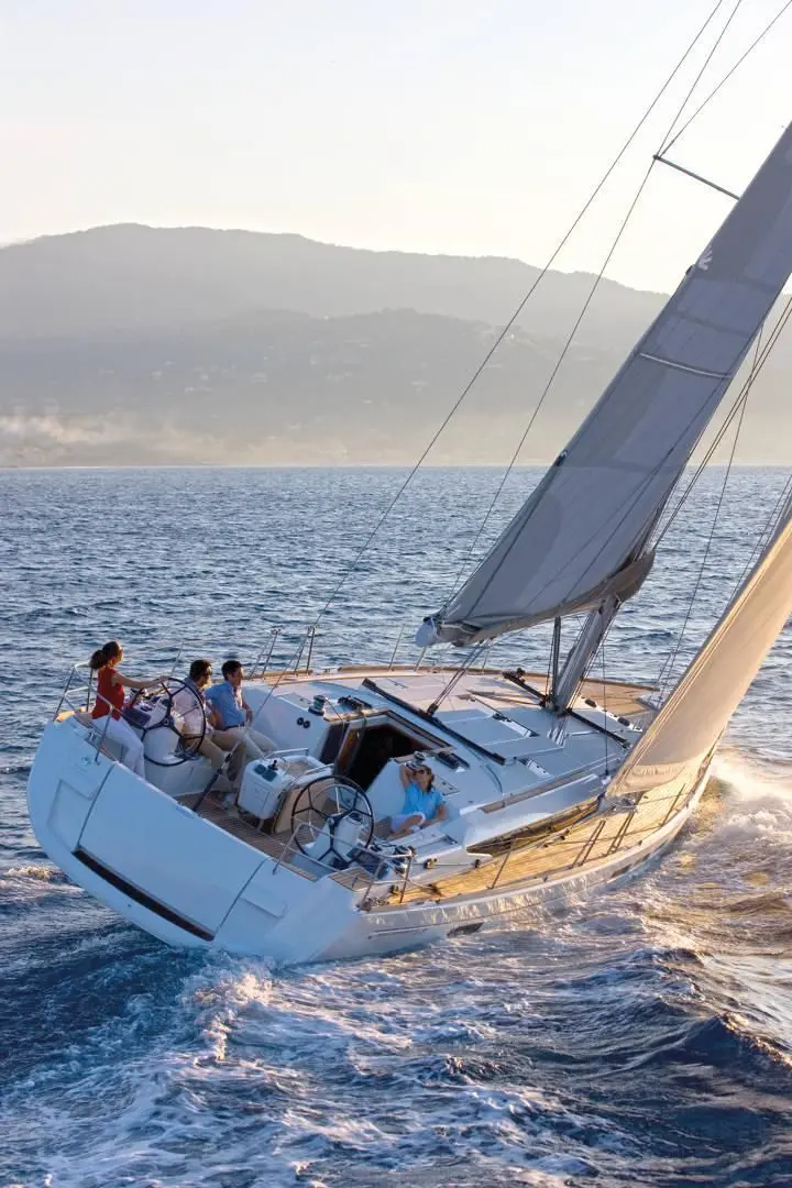 Jeanneau Sun Odyssey 519 — Voilier naviguant au large, vu de trois quarts, avec plusieurs personnes à bord.