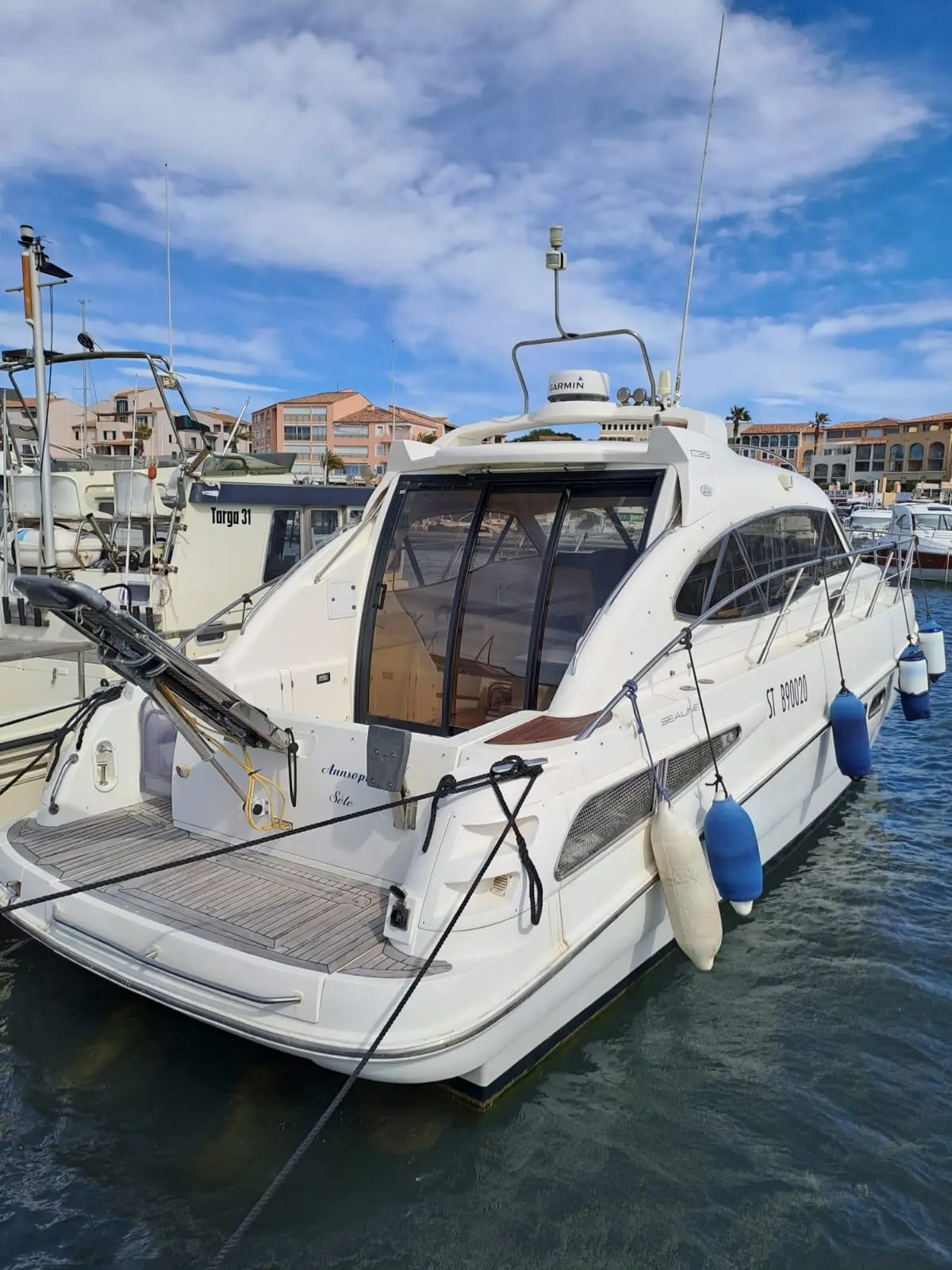 Sealine C 39 — Bateau à moteur blanc amarré, vu de trois quarts arrière dans un port.