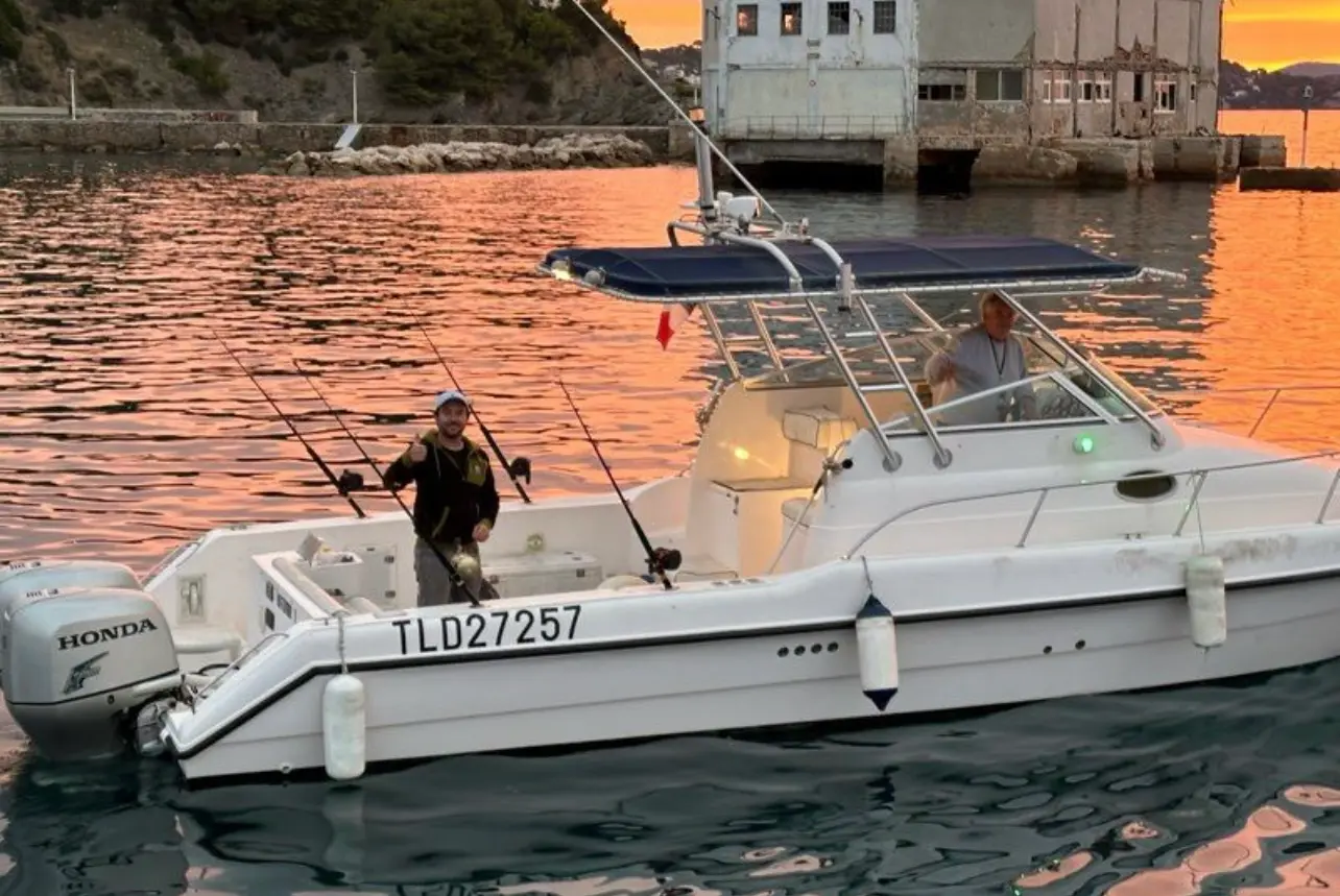 Gulf Craft 31 WA — Bateau à moteur blanc amarré, avec deux personnes à bord et plusieurs cannes à pêche.