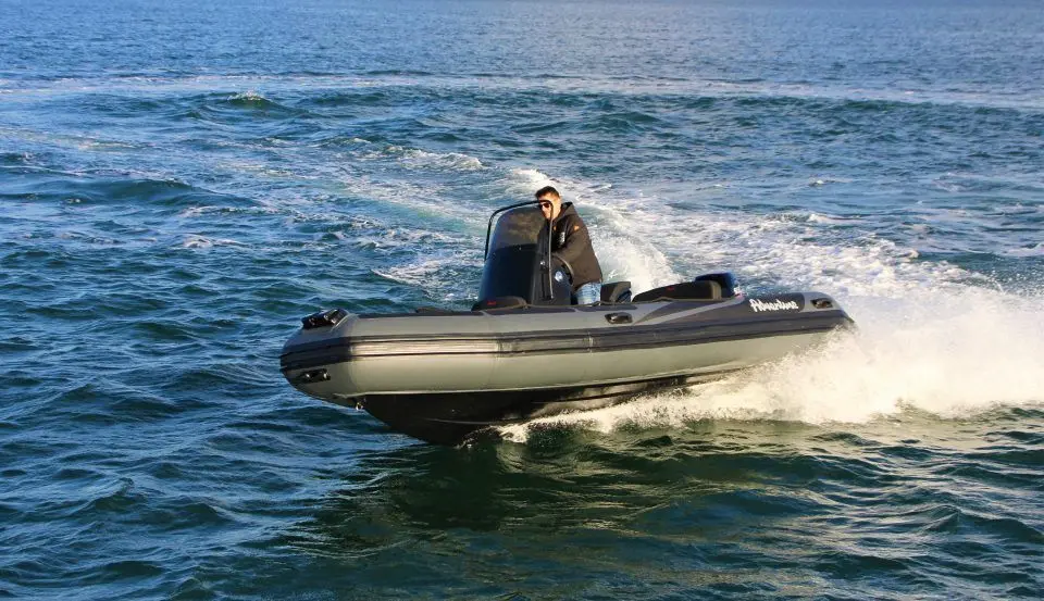 Adventure Vesta 550 Profish — Un bateau semi-rigide navigue rapidement sur une mer agitée, avec un pilote à bord.