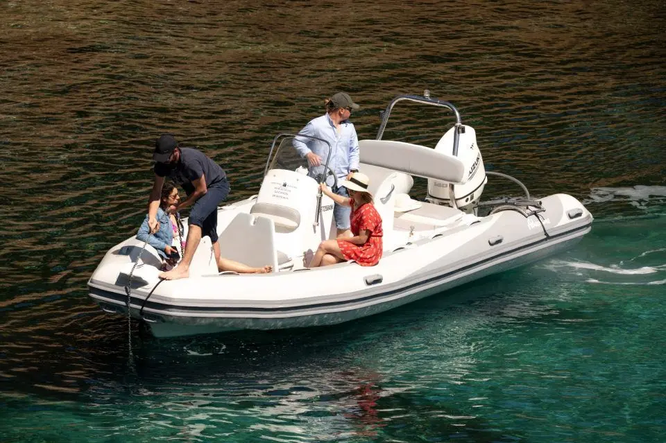 Adventure Vesta 650 Élite — Bateau pneumatique blanc avec console centrale et quatre personnes sur l’eau.