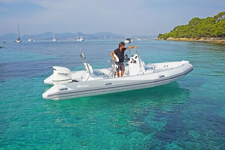 Adventure Vesta 650 Élite — Bateau semi-rigide blanc avec moteur hors-bord, photographié dans une baie.