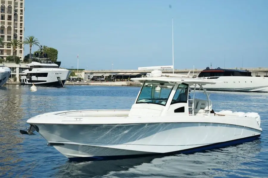 Boston Whaler 370 Outrage — Bateau à moteur blanc photographié de trois quarts dans une marina.