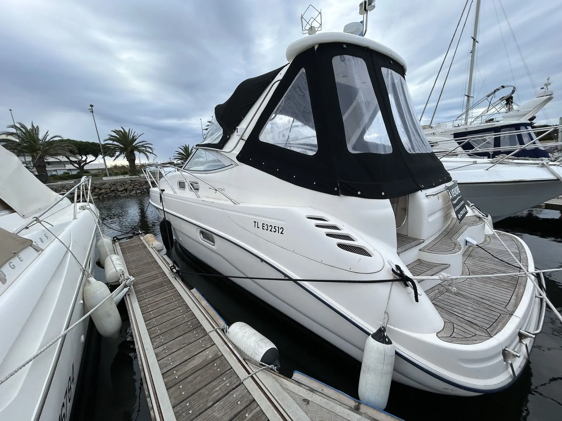 Sealine S 34 — Bateau à moteur blanc amarré au ponton, vu de trois quarts arrière.