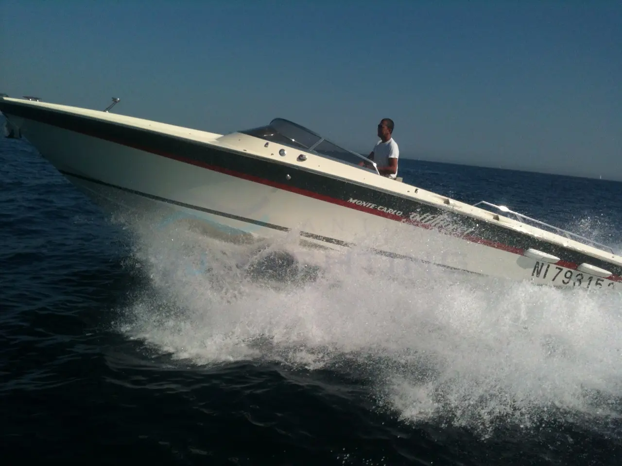 Monte Carlo Offshorer 30 — Bateau à moteur blanc et rouge naviguant rapidement en mer, avec un homme à bord.