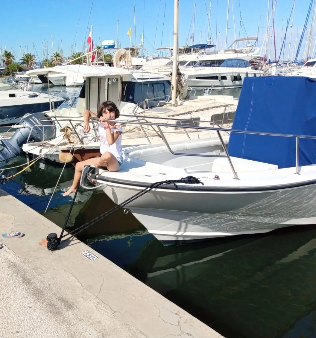 Boston Whaler 24 Outrage — Bateau à moteur amarré dans un port, avec une personne assise à l’avant.