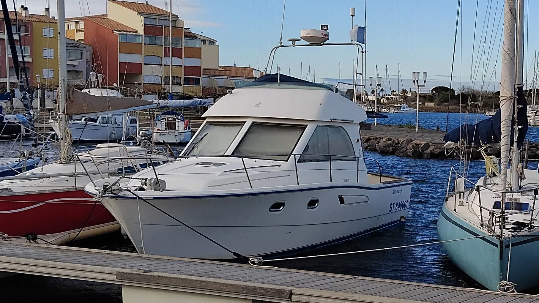 Beneteau Antares 905 — Bateau à moteur blanc amarré dans un port, vu de trois quarts avant.