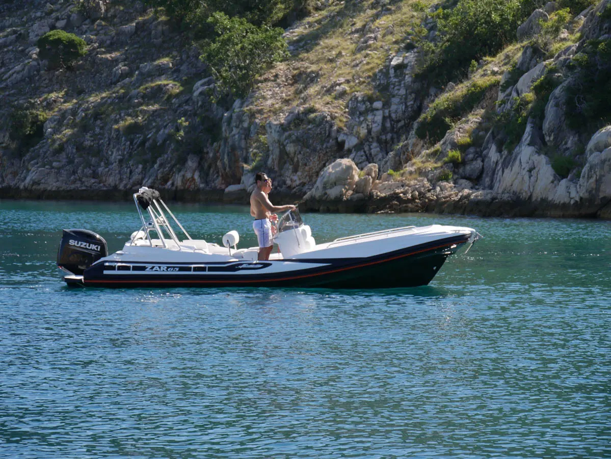 Zar Formenti Zar 65 Suite — Bateau semi-rigide blanc et noir naviguant devant une côte rocheuse.