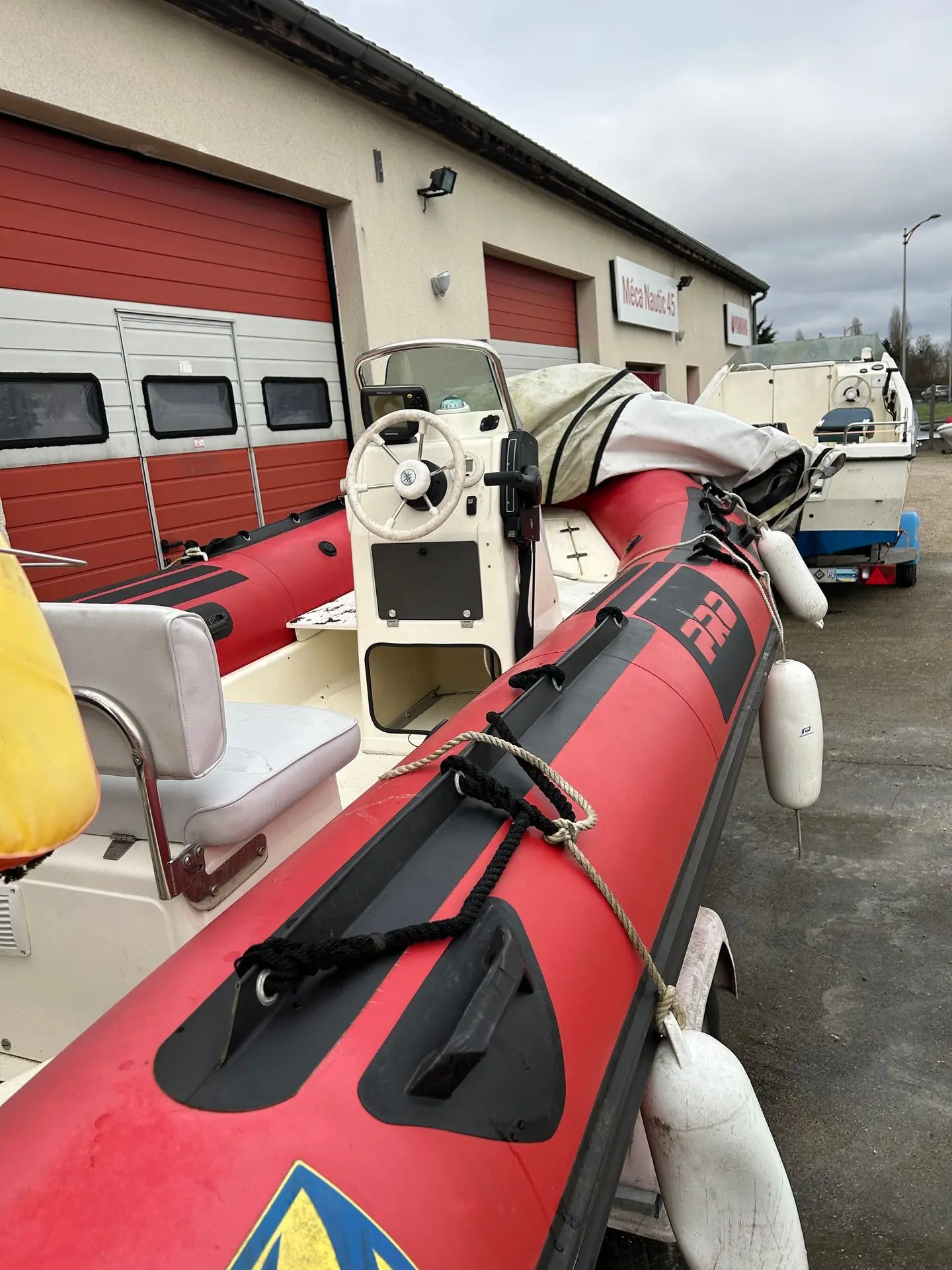 Zodiac Pro 9 Man — Vue rapprochée du poste de pilotage et des flotteurs rouges d’un bateau pneumatique.
