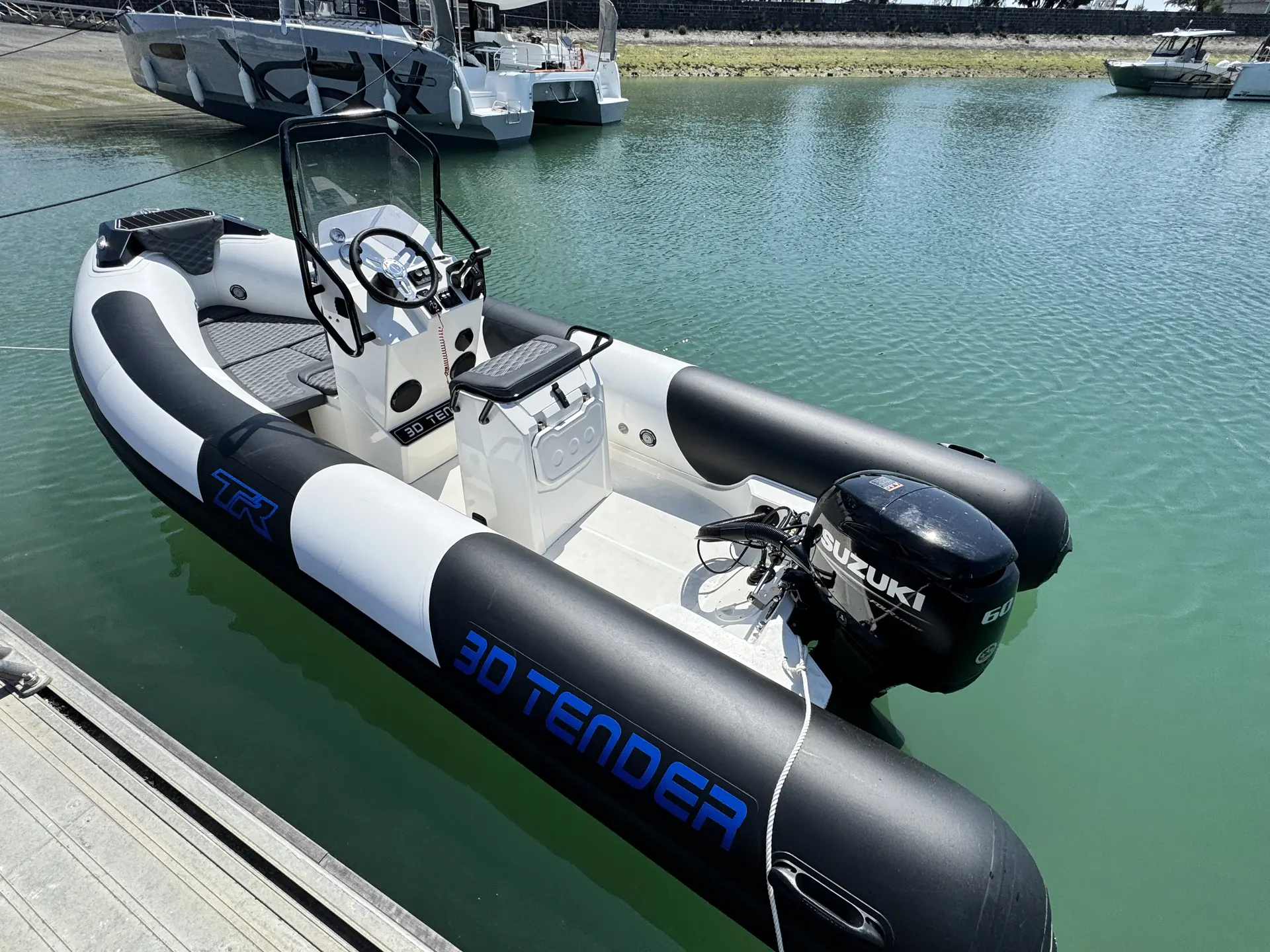 3D Tender TR 54 — Bateau pneumatique à console et moteur hors-bord amarré dans un port.