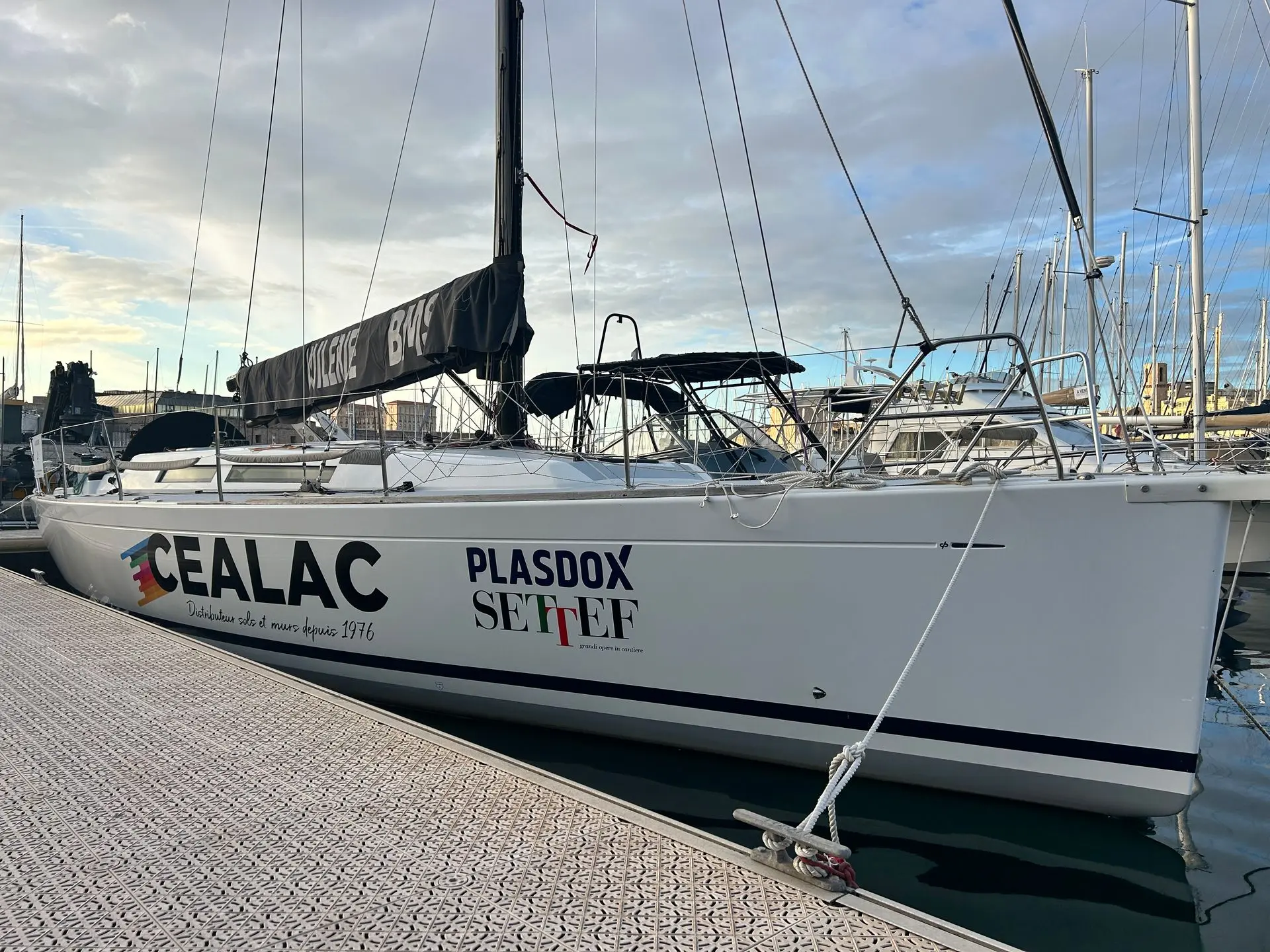 Grand Soleil 37 — Voilier blanc amarré au port, vu de profil avec sa grand-voile ferlée.