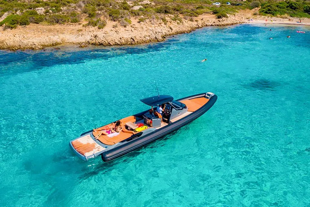 Sacs Strider 13 — Vue aérienne d’un bateau semi-rigide au mouillage dans une eau turquoise.