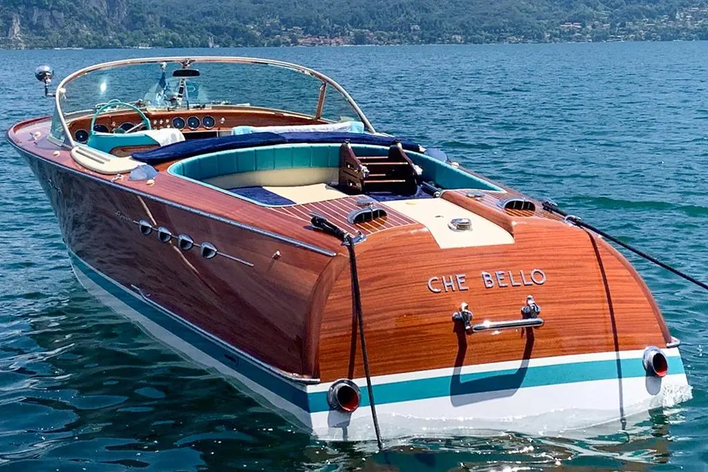 Riva Aquarama — Bateau runabout en bois photographié de trois quarts arrière sur un lac.
