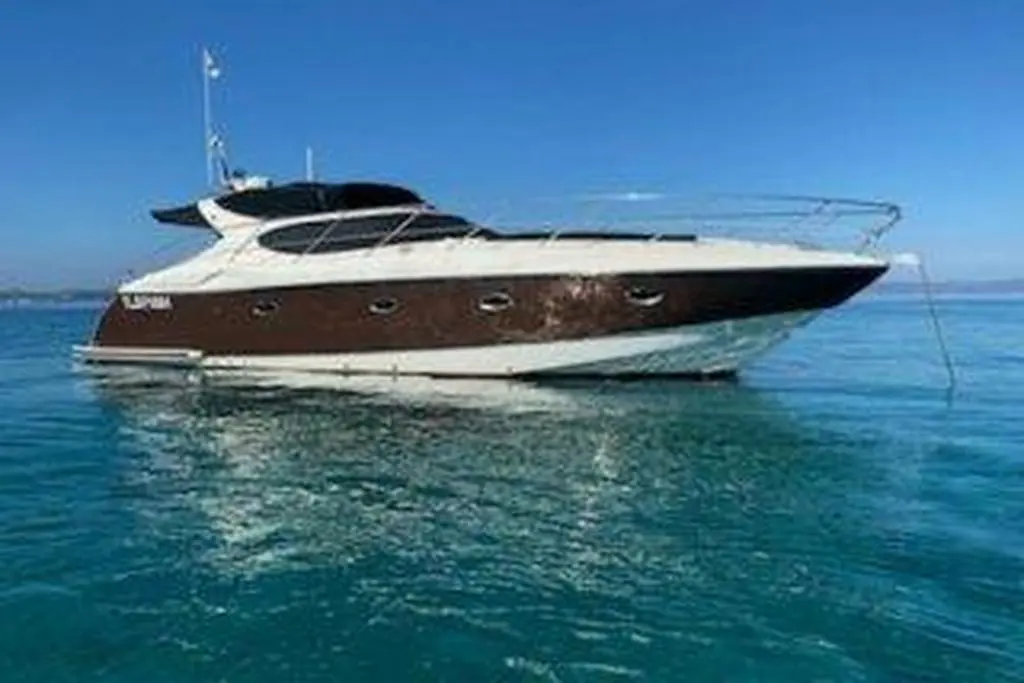 Neptunus 41 Sport — Bateau à moteur blanc et brun photographié de profil sur une mer calme.