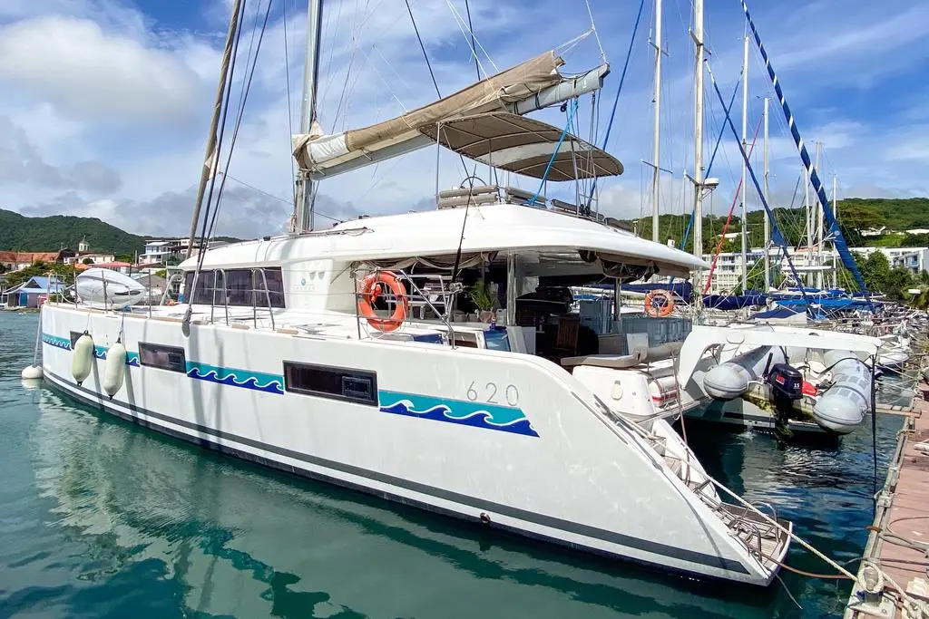 Lagoon 620 — Catamaran blanc amarré dans une marina, vu de trois quarts bâbord.