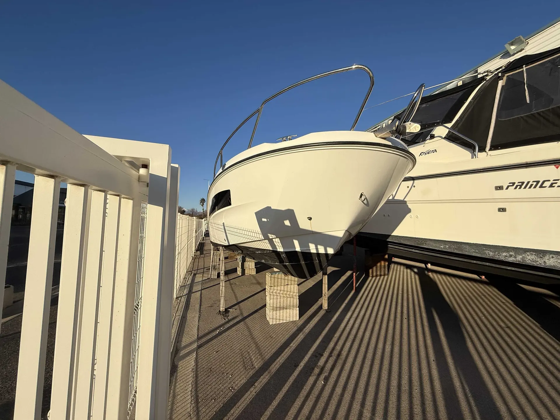 Karnic SL601 — Bateau à moteur blanc photographié sur bers dans une cour extérieure.