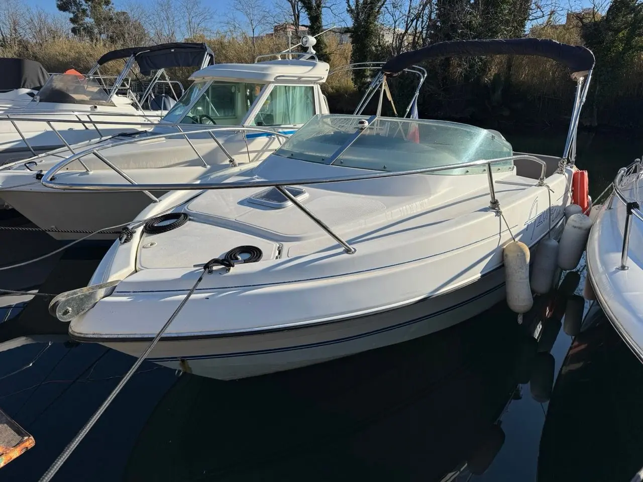 Kelt Azura 575 — Vedette blanche amarrée dans un port, vue de trois quarts avant.