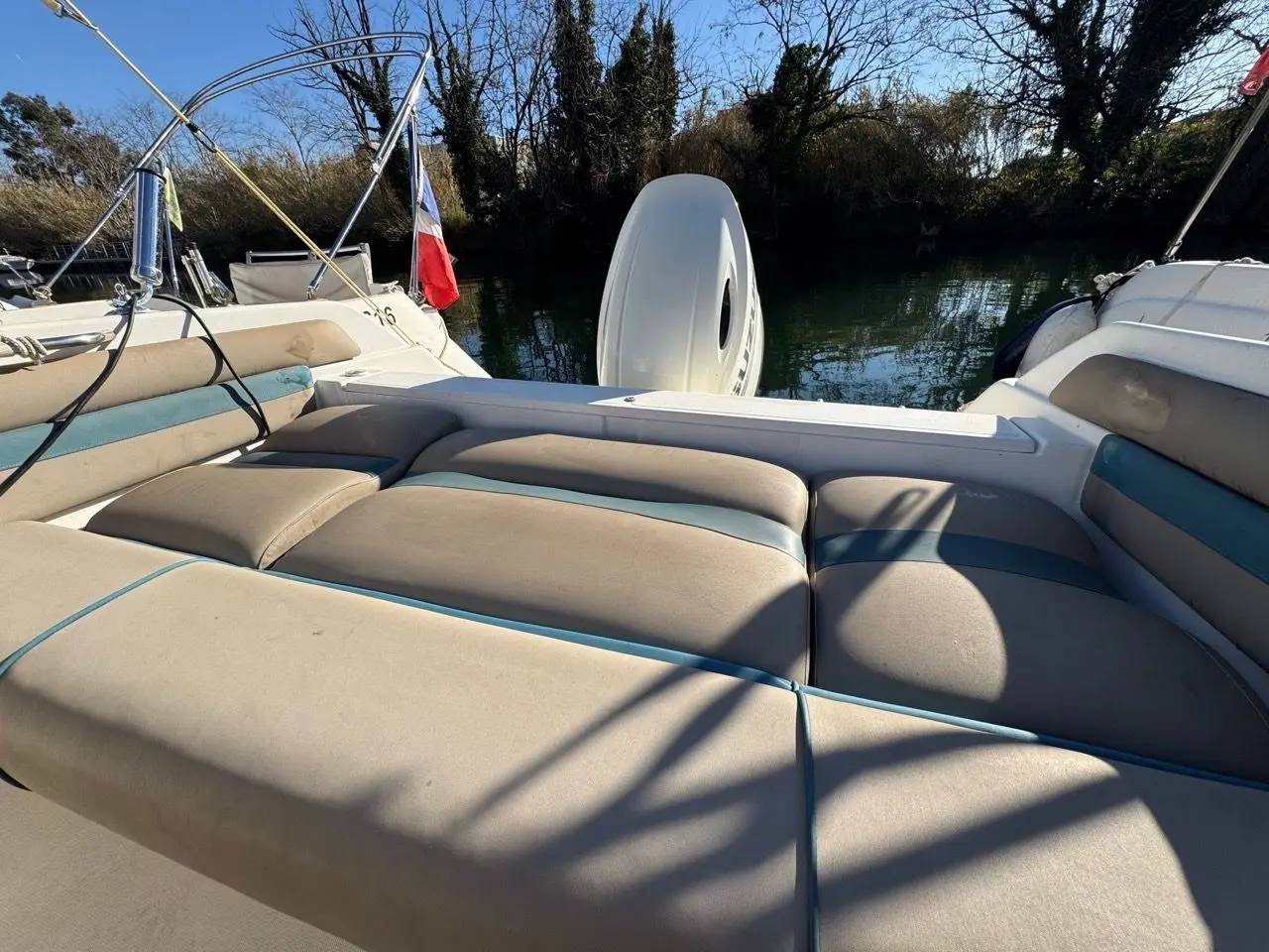 Kelt Azura 575 — Vue du cockpit arrière avec banquettes, moteur hors-bord relevé et pavillon français.