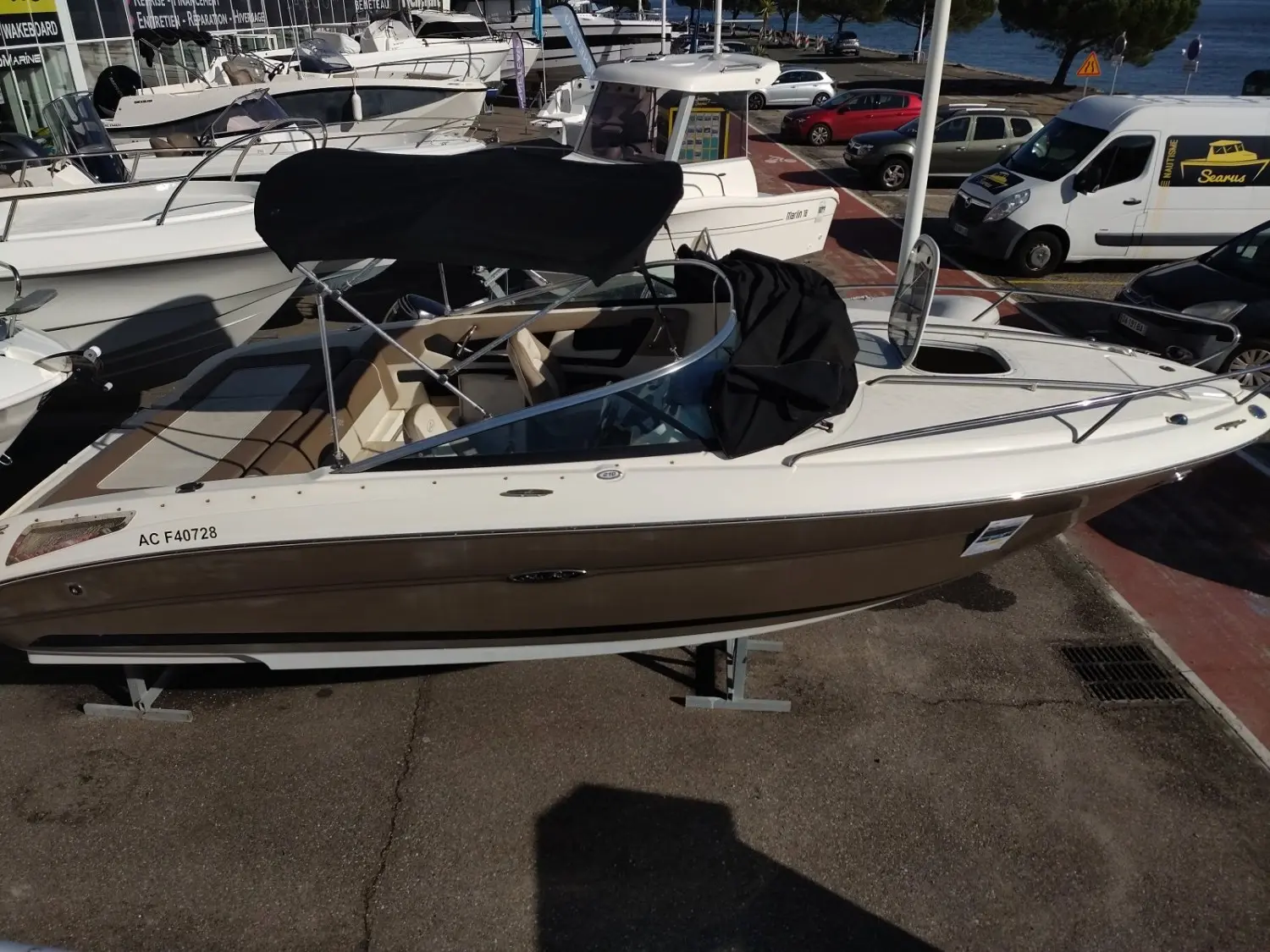 Sea Ray 210 — Bateau de plaisance blanc et brun présenté sur une remorque dans un port.