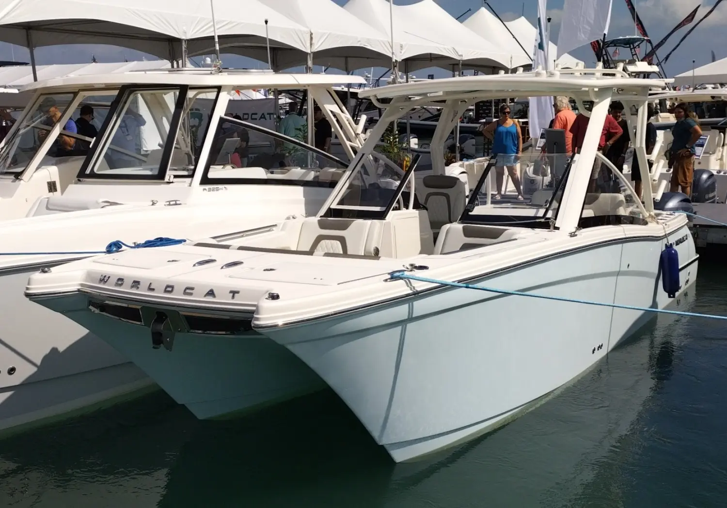 World Cat 280 Dc-x — Bateau à moteur blanc photographié de trois quarts dans un salon nautique.