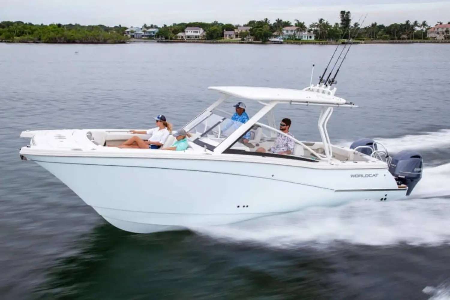 World Cat 280 Dc-x — Bateau à moteur blanc naviguant avec plusieurs passagers près du rivage.
