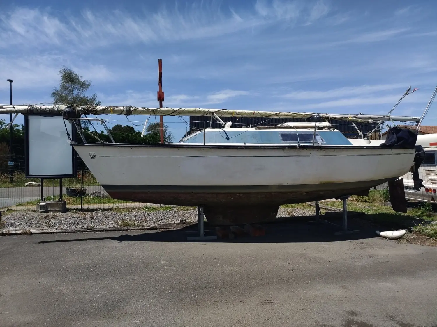 Dufour 1800 — Voilier blanc présenté à terre, vu de profil dans un environnement portuaire.