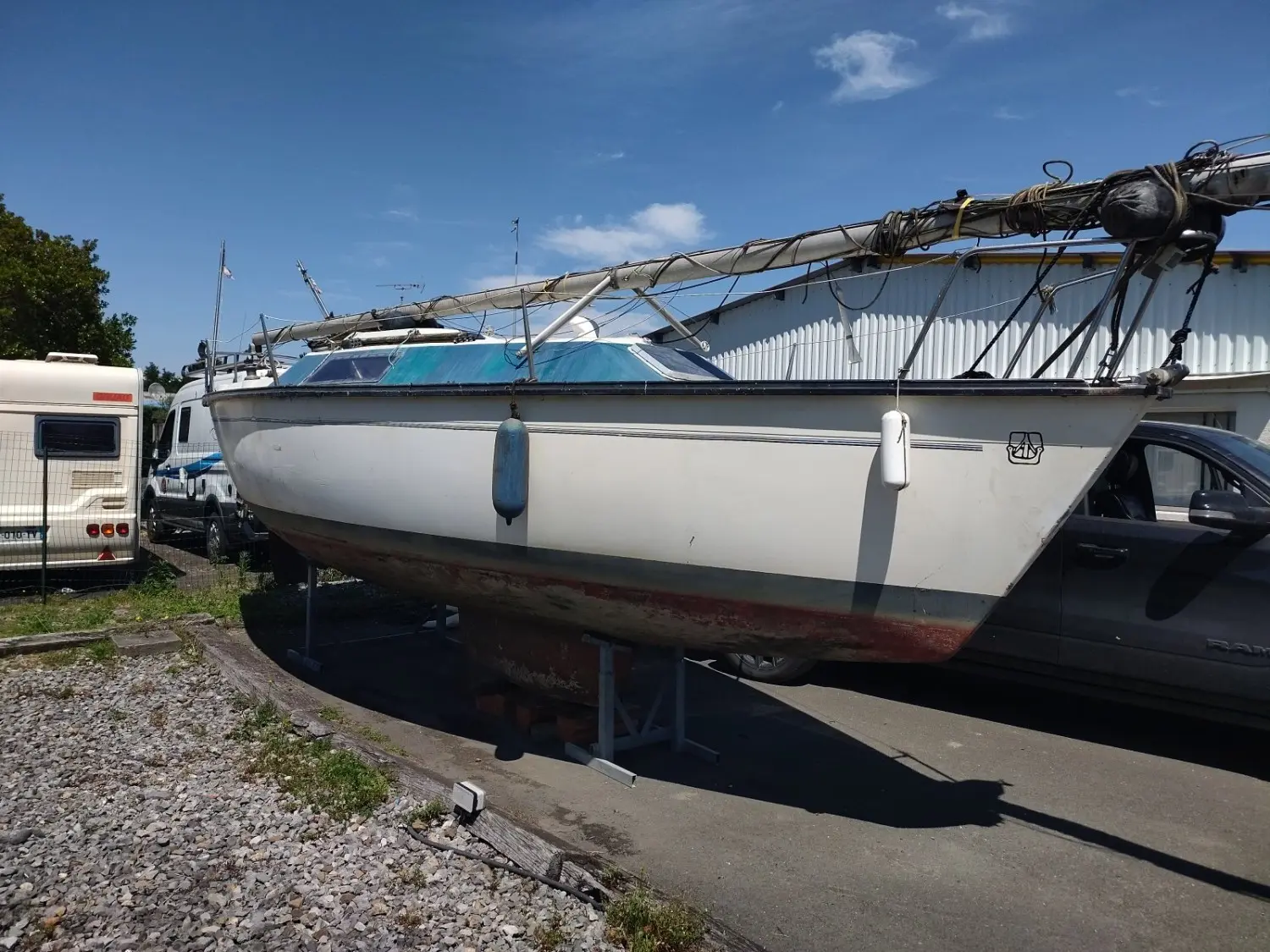 Dufour 1800 — Voilier blanc posé à terre, photographié de profil devant un bâtiment.
