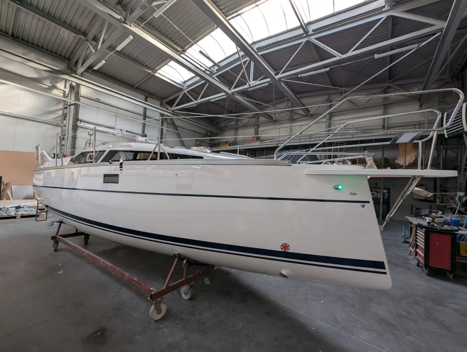 Tes 246 — Bateau blanc photographié de profil dans un hangar, posé sur une remorque.