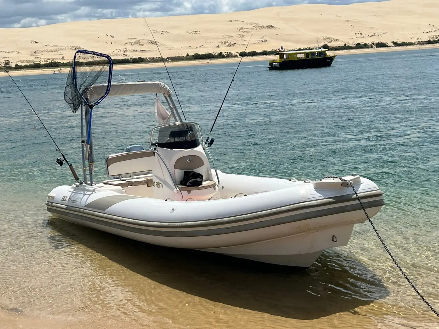 BSC 57 — Bateau pneumatique blanc à console, amarré dans une eau peu profonde.