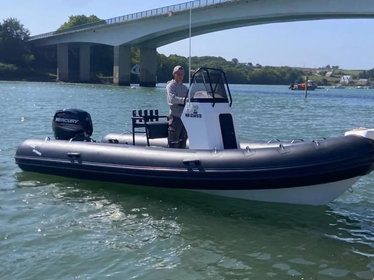 Evok Marine Evok 19 Fishing — Bateau pneumatique à console centrale naviguant sous un pont.