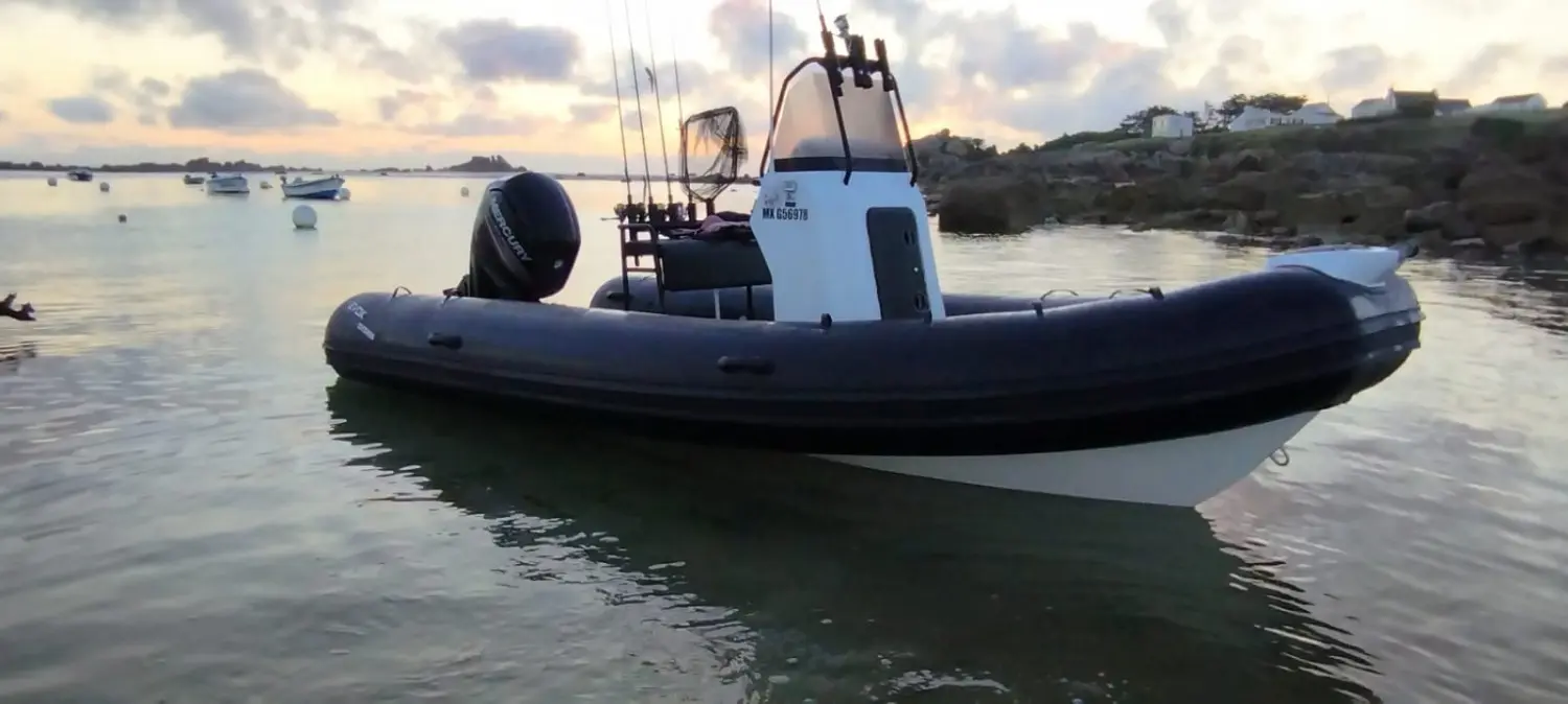 Evok Marine Evok 19 Fishing — Bateau pneumatique à moteur hors-bord amarré dans une baie au coucher du soleil.