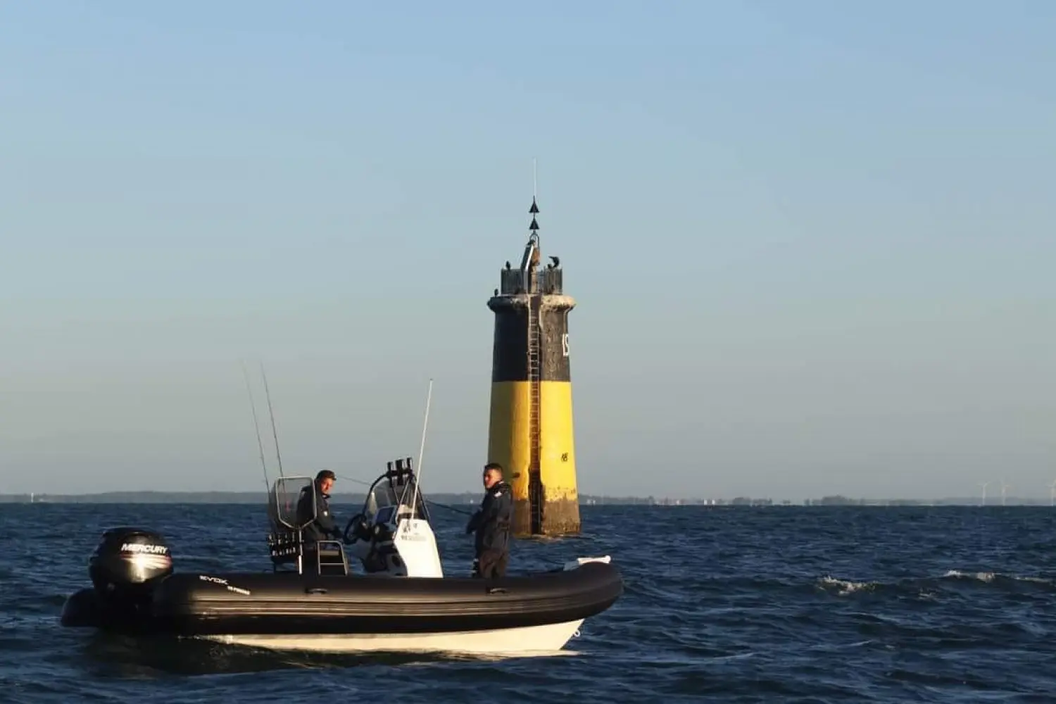 Evok Marine Evok 19 Fishing — Bateau pneumatique naviguant devant une balise en mer