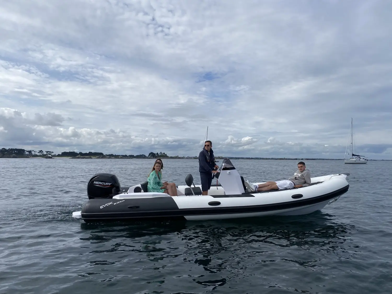 Evok Marine Evok 21 Ocean — Bateau pneumatique vu de profil sur l’eau avec trois personnes à bord.