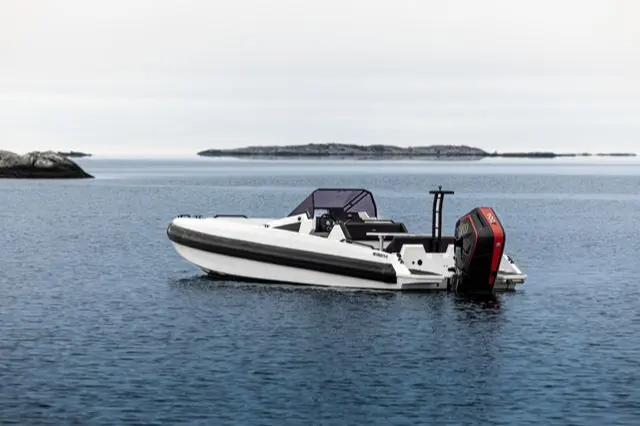 Iron Boats 907 — Bateau semi-rigide blanc et noir vu de trois quarts sur une mer calme.