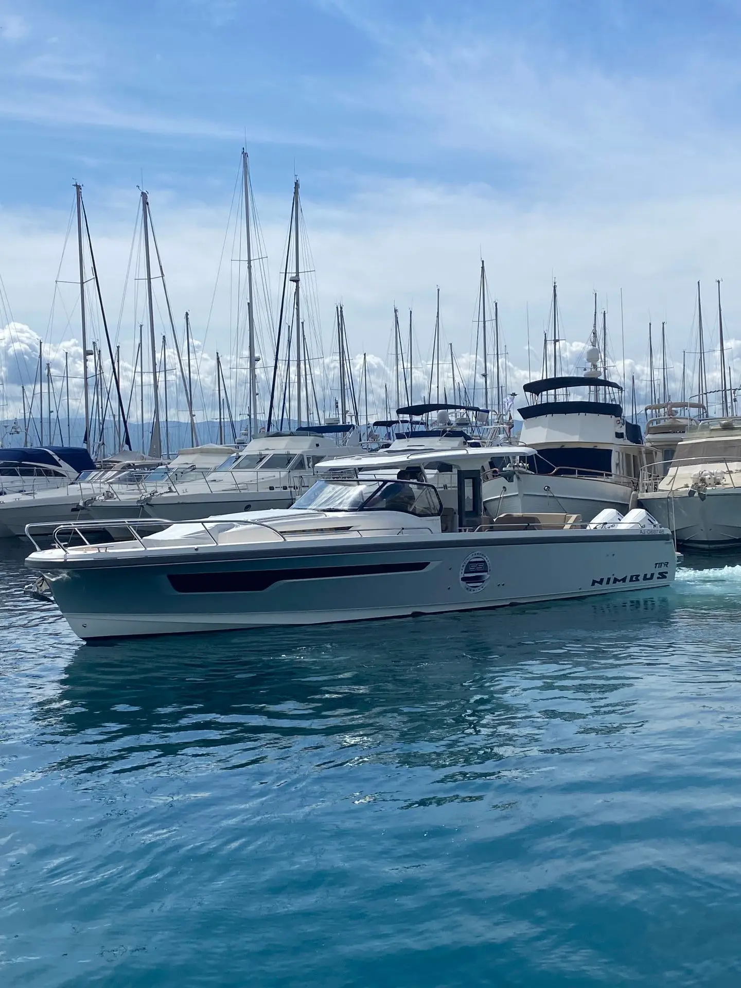 Nimbus T11 — Bateau à moteur vu de profil dans une marina, parmi d’autres embarcations.