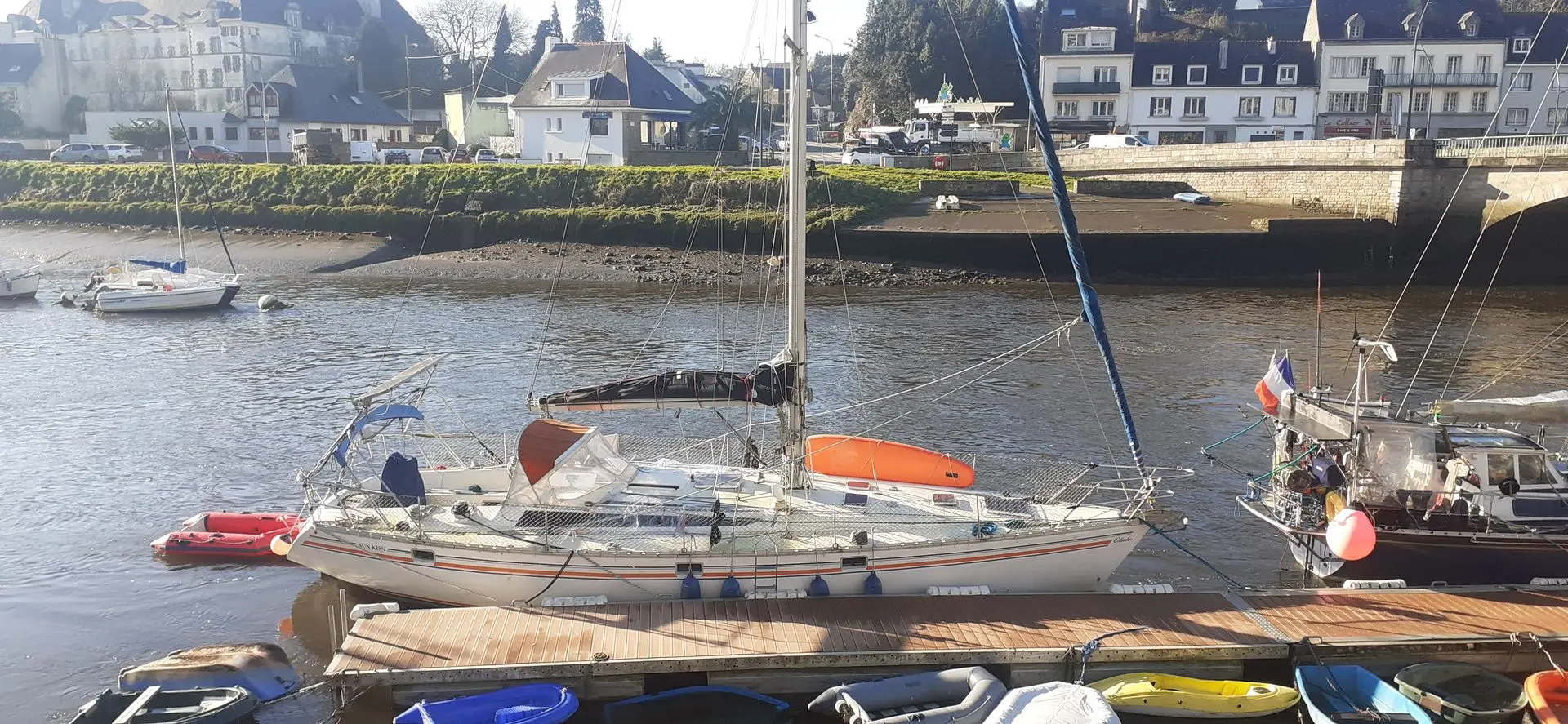 Jeanneau Sun Kiss 45 — Voilier amarré à quai, vu de profil dans un port à marée basse.