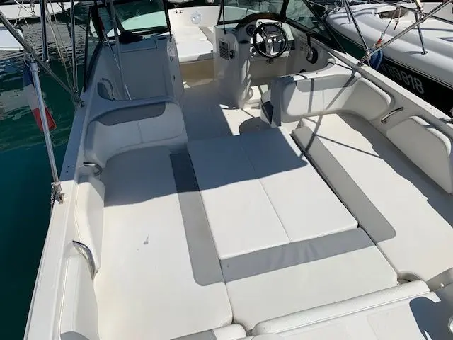 Bayliner E7 — Vue du cockpit avec sièges, bain de soleil et poste de pilotage.