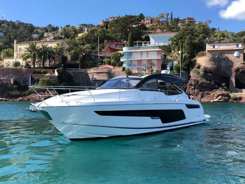 Fairline Targa 50 Open — Bateau à moteur blanc vu de profil dans une baie résidentielle.