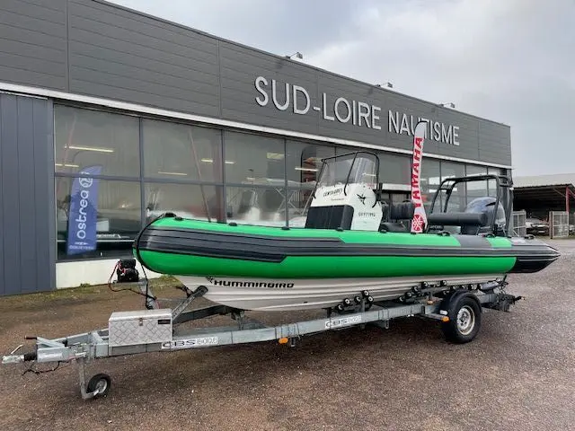 Centaure 660 — Bateau pneumatique vert et noir présenté sur une remorque devant un concessionnaire nautique.