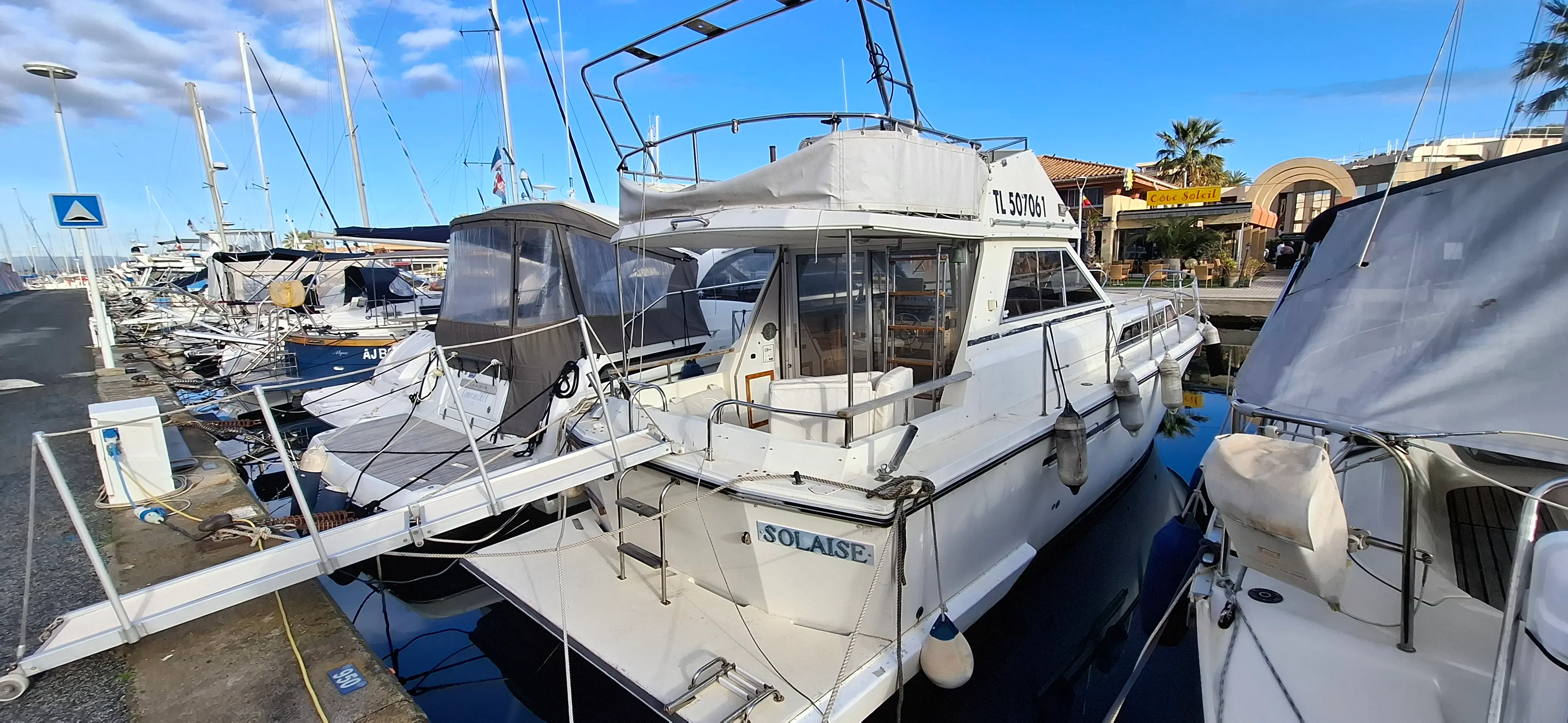 Princess 33 — Vedette blanche photographiée de trois quarts arrière dans un port de plaisance.