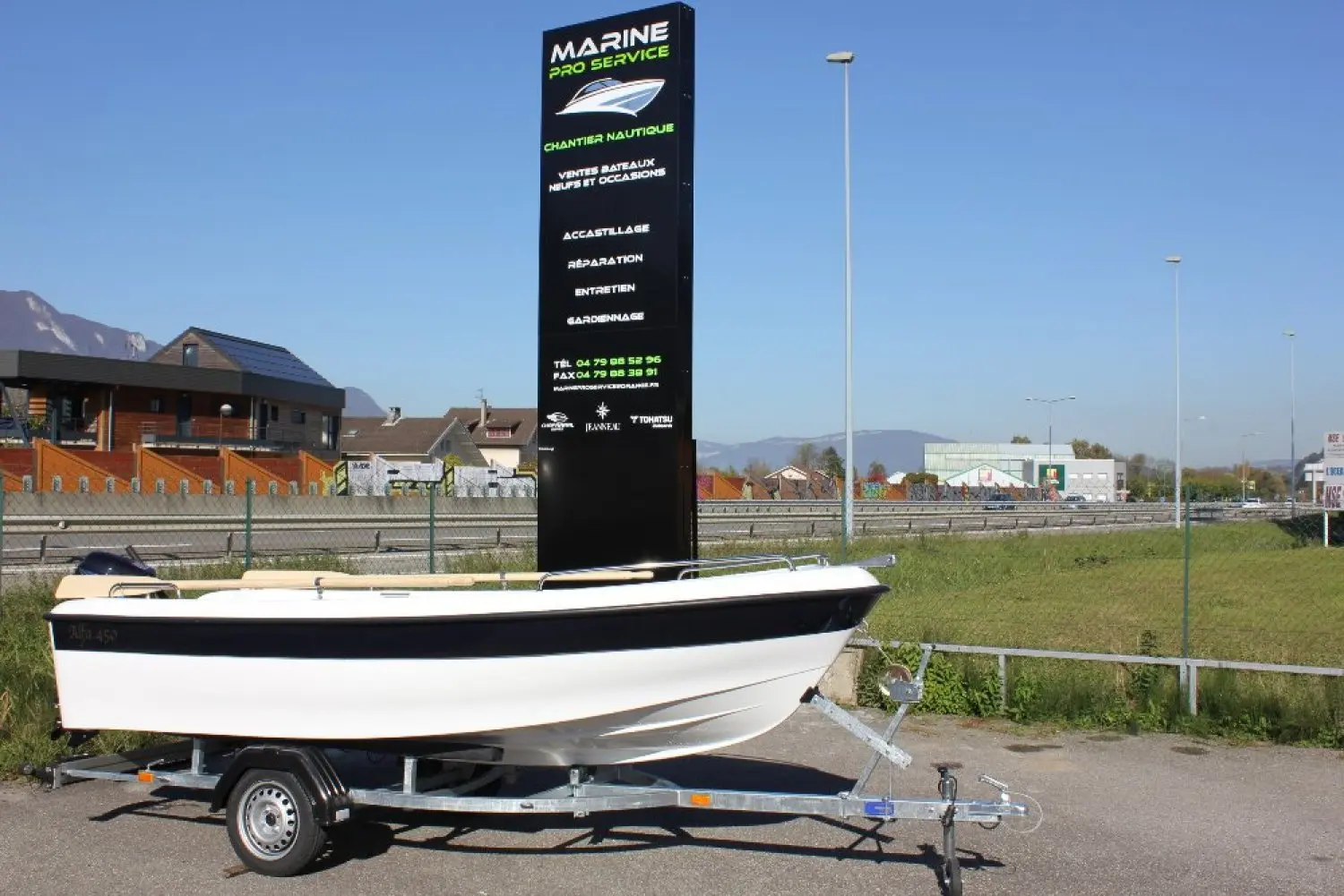 Titanium Alfa 450 — Bateau à moteur blanc et noir présenté sur une remorque à terre.