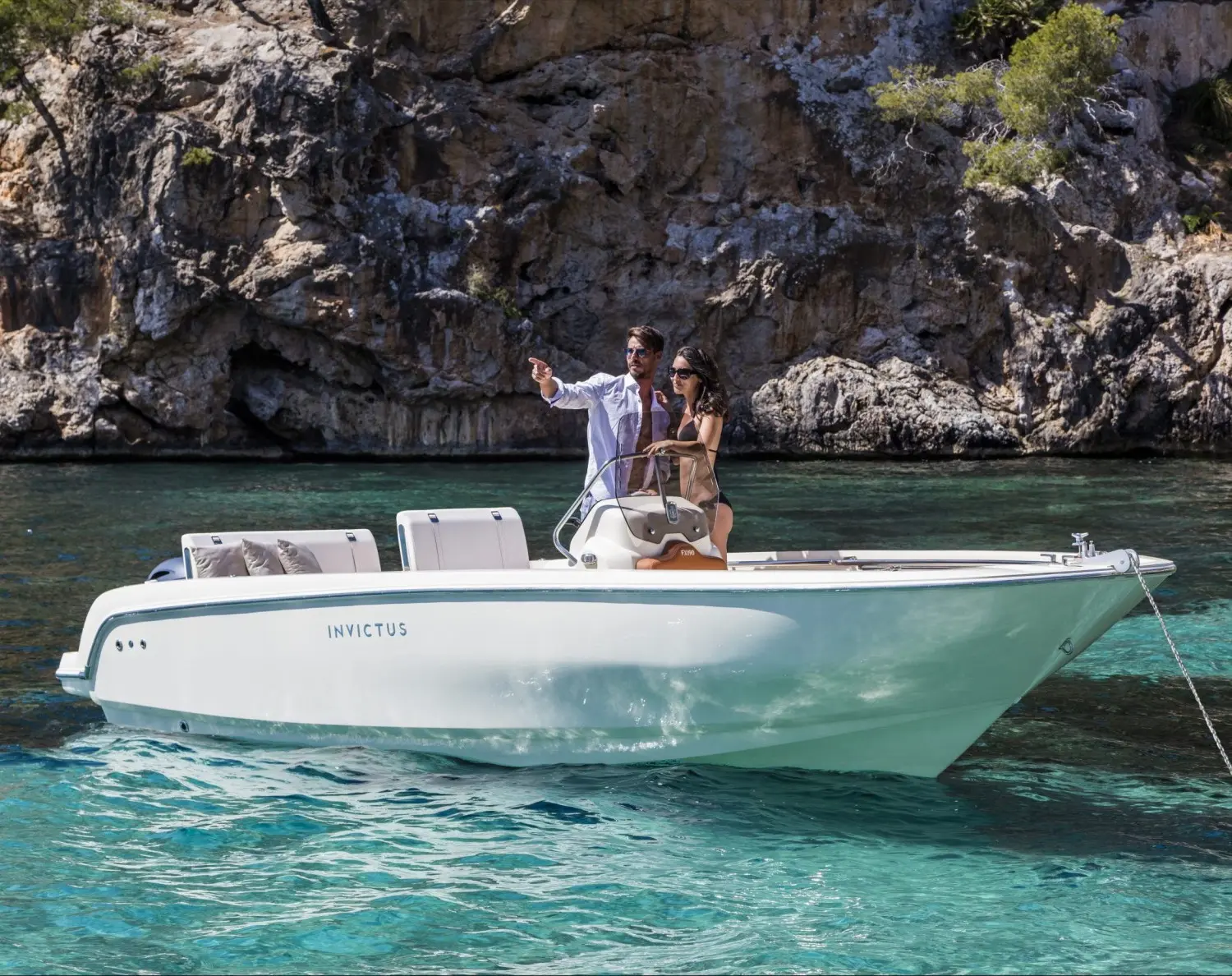 Invictus Capoforte FX 190 — Bateau à moteur blanc vu de profil dans une crique rocheuse.